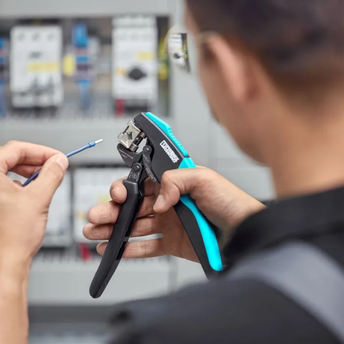 Panel assembly technician crimping a ferrule with Phoenix Contact CRIMPFOX pliers